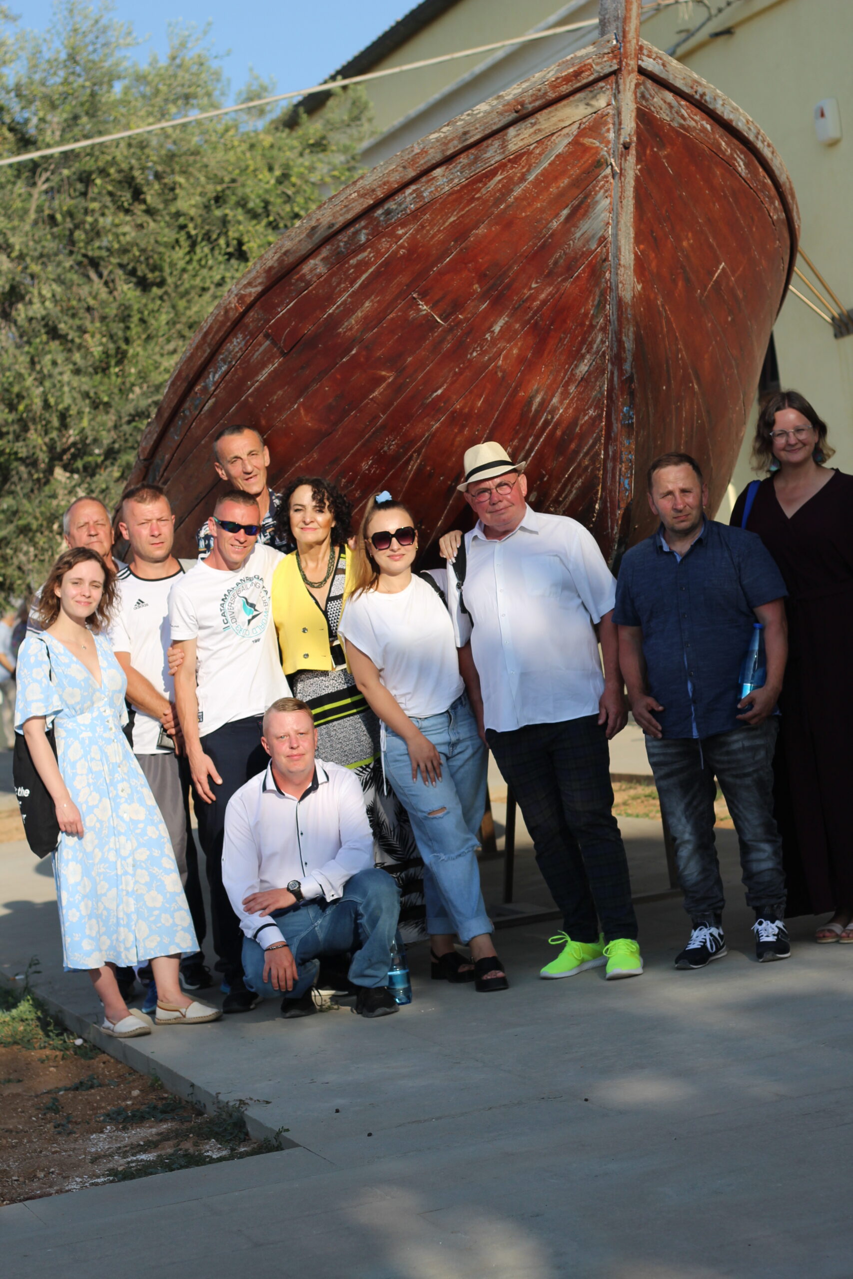 Delegacie z Sieci Barka przed pamiątkową łodzią na wyspie Lampedusa